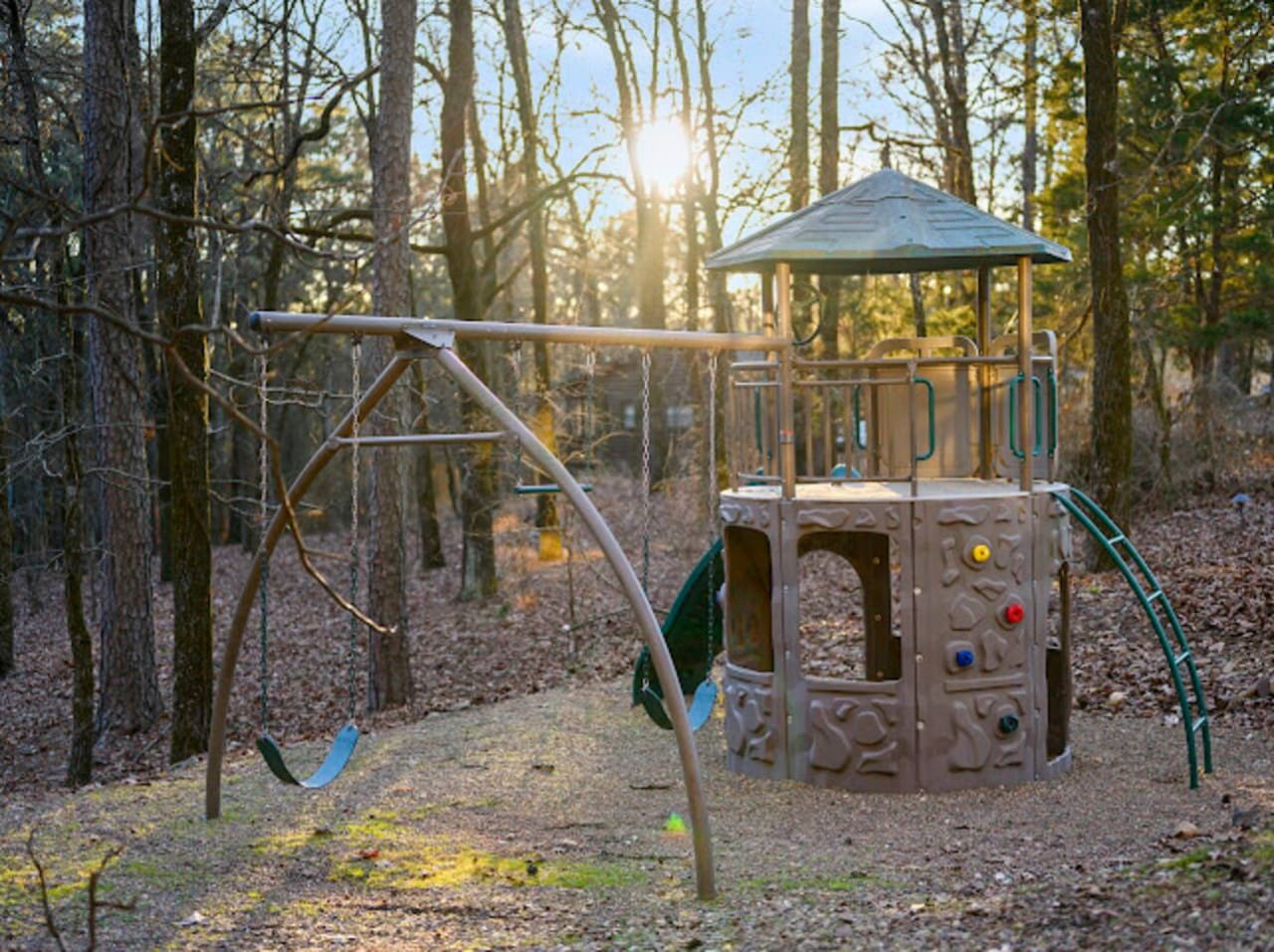 Kids will love playing in this peaceful wooded playground with swings and climbing structures right on the property.