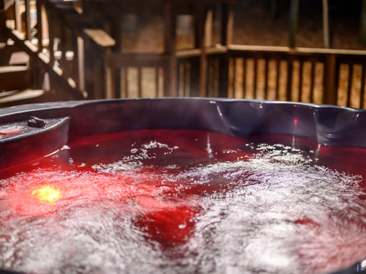 Soak in the steaming hot tub while taking in the serene wooden deck and mountain views.