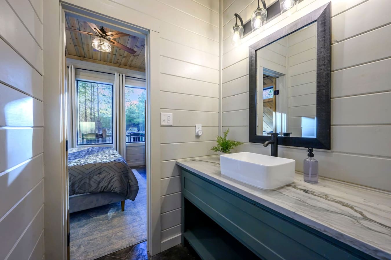 This modern ensuite bathroom features a sleek vessel sink, spacious marble countertop, and direct access to the bedroom.