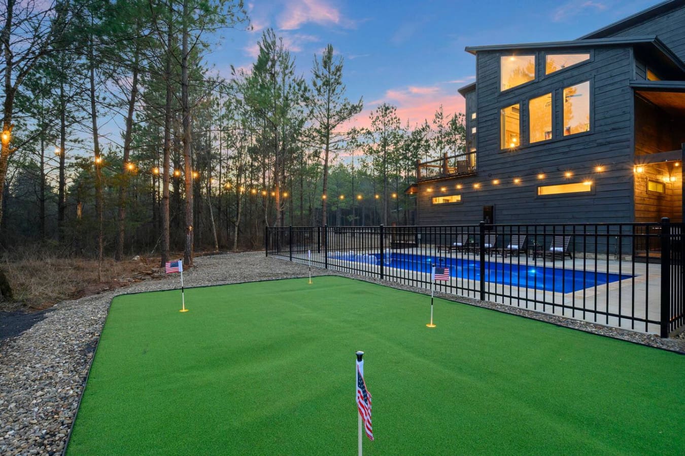Nothing says vacation vibes like a putting green and pool in your own backyard surrounded by tall pines.