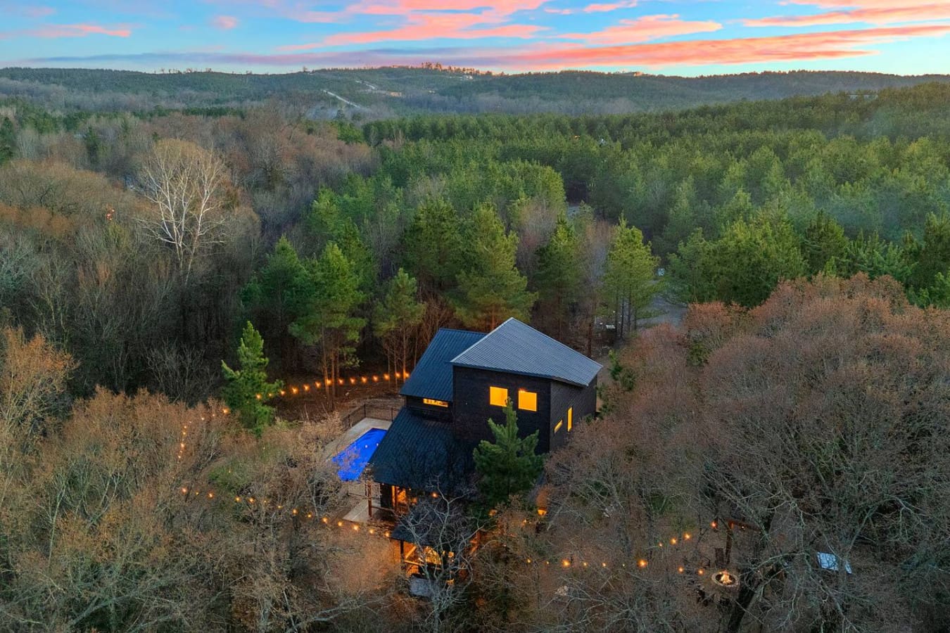 This stunning black modern retreat sits nestled in the forest with a heated pool and those incredible mountain views at sunset.