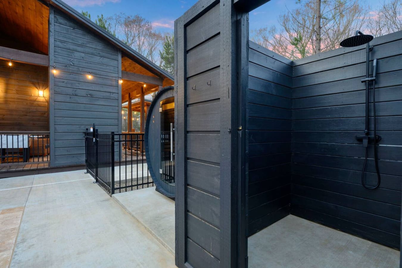 This outdoor shower setup is absolutely stunning with its sleek black finishes and open-air design overlooking the property.