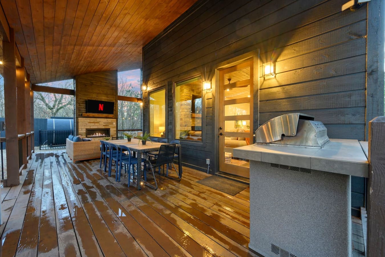 This covered deck is basically an outdoor living room with a fireplace, dining area, and built-in grill.
