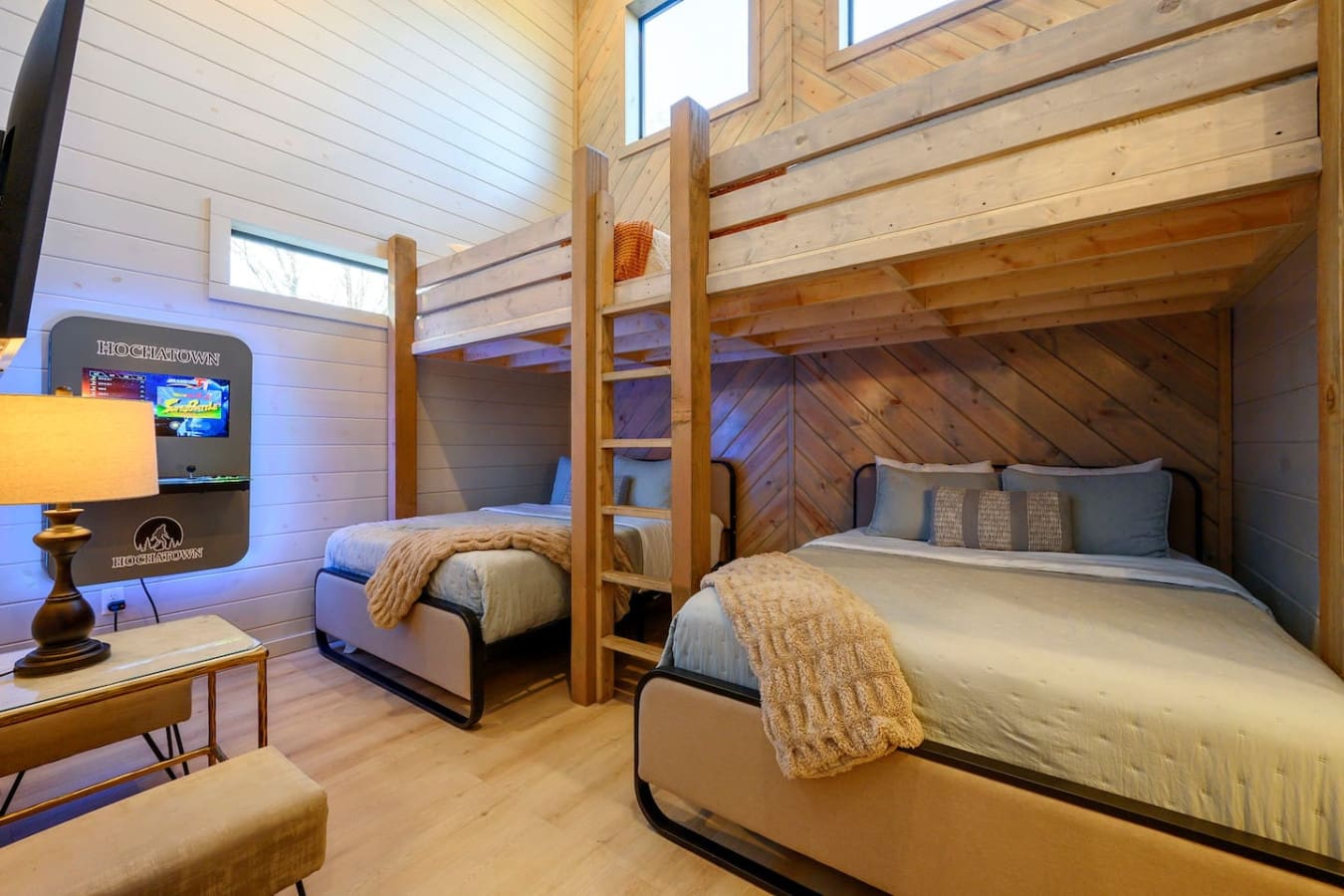 This gorgeous cabin bedroom sleeps four with cozy bunk beds, soaring wood beams, and those huge skylights flooding the space with natural light.