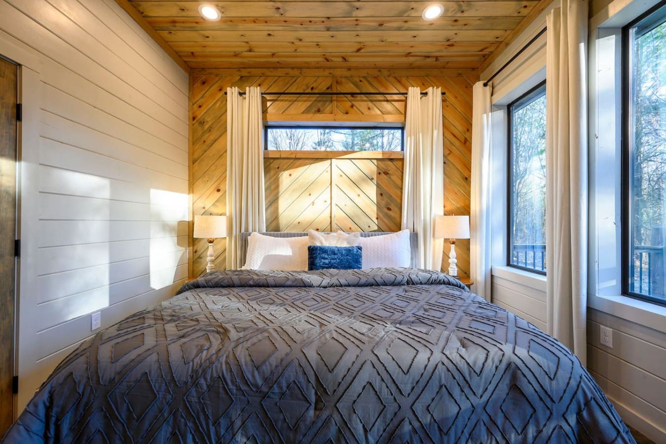 This dreamy canopy bed with those exposed wood ceilings and forest views is basically peak cozy luxury.