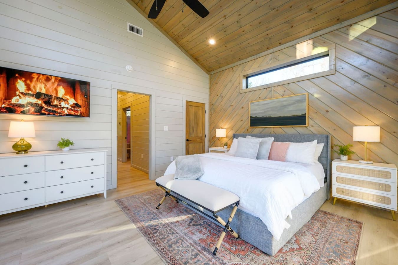 This stunning master bedroom features vaulted wood ceilings, a fireplace, and tons of natural light from the skylight.