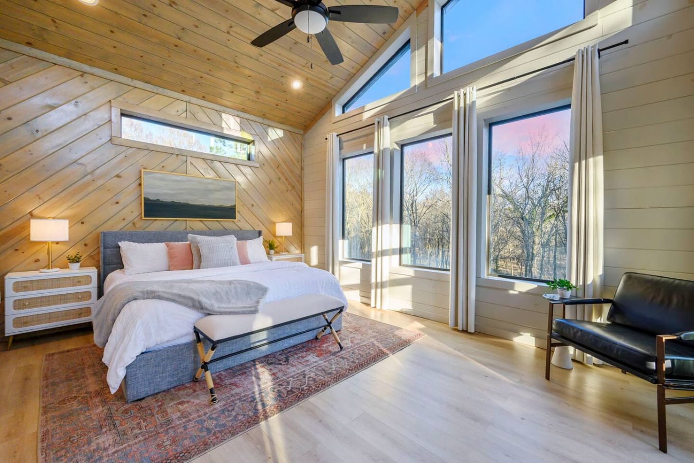 Wake up to floor-to-ceiling windows and a vaulted wood ceiling in this stunning modern bedroom retreat.