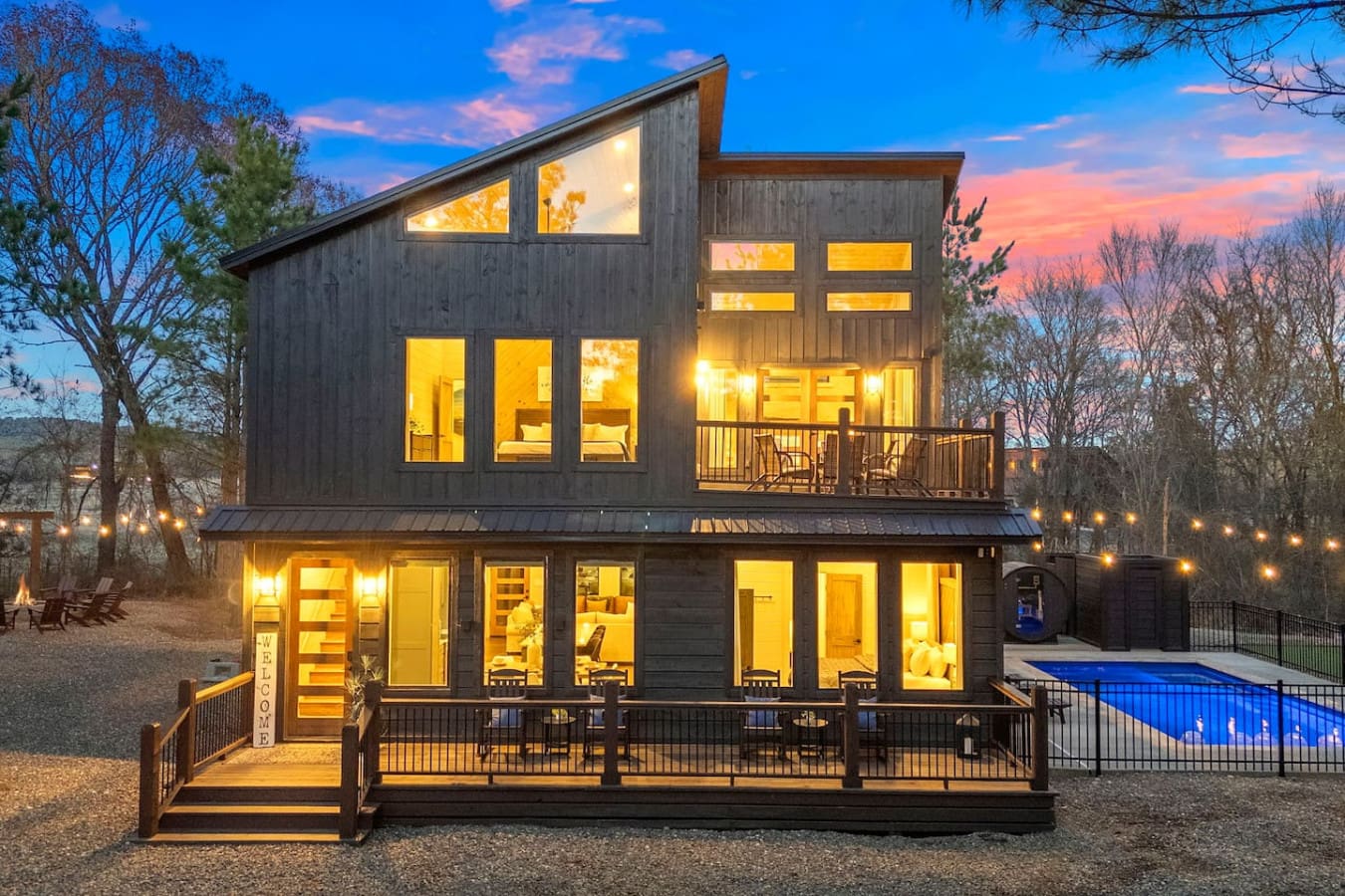 This stunning modern home lights up beautifully at dusk with a resort-style pool and wraparound decks perfect for entertaining.