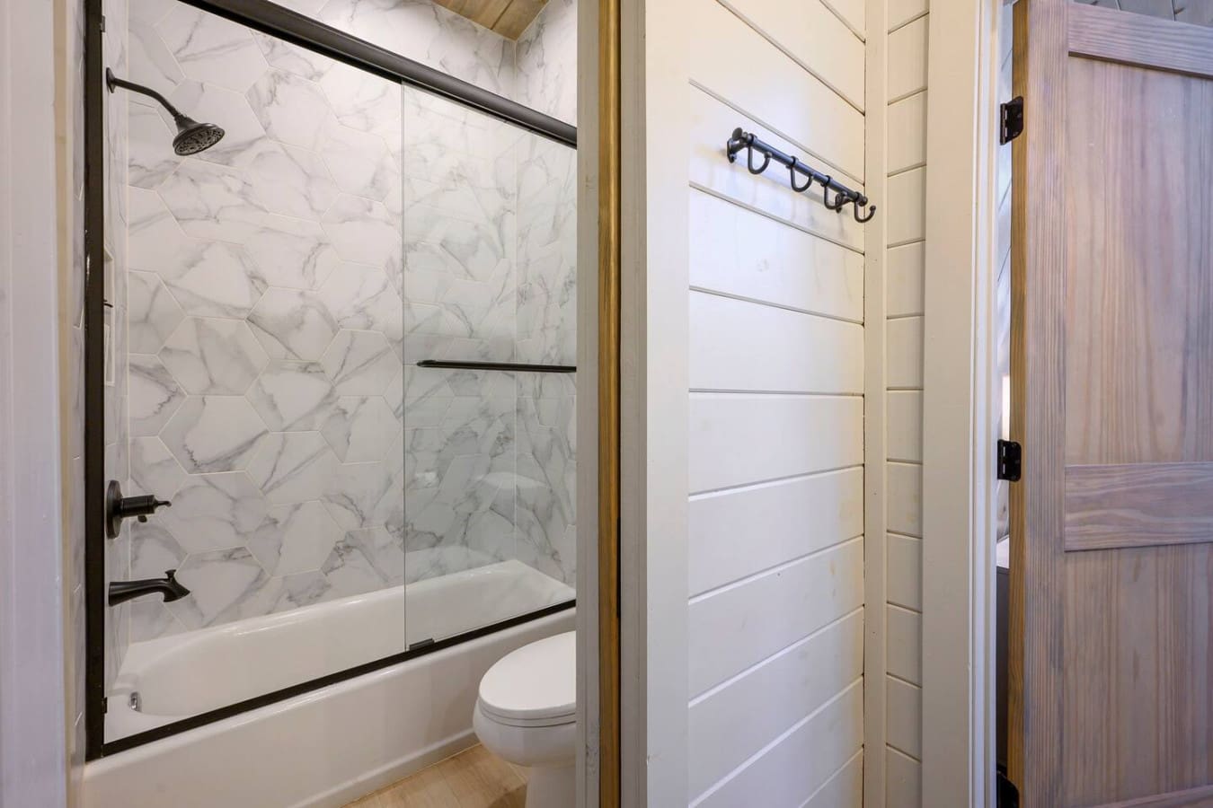 This spa-like ensuite features elegant marble tile work, a spacious walk-in shower, and modern finishes.