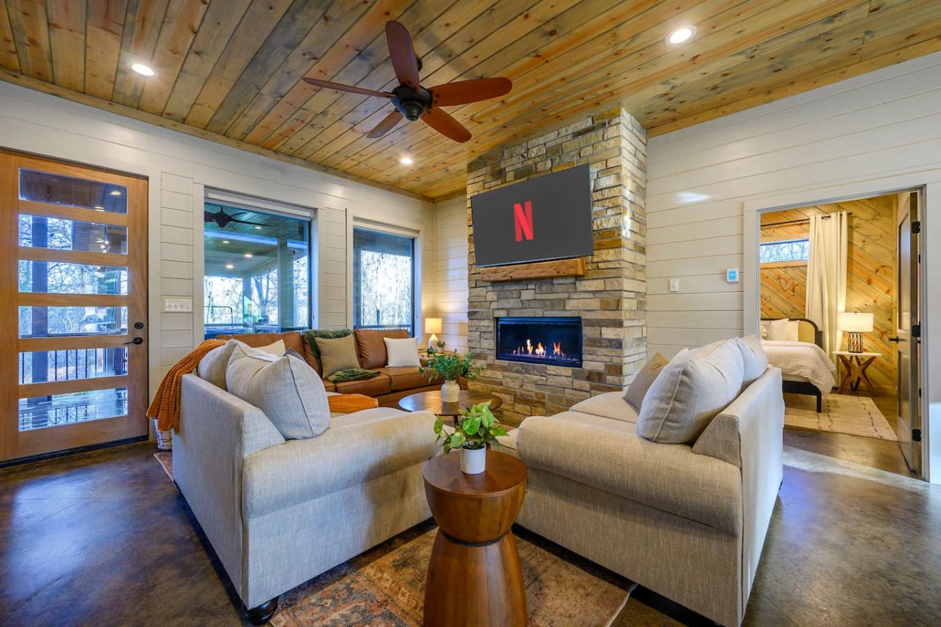 This cozy living room has everything you need to relax—a fireplace, TV, comfy seating, and tons of natural light.