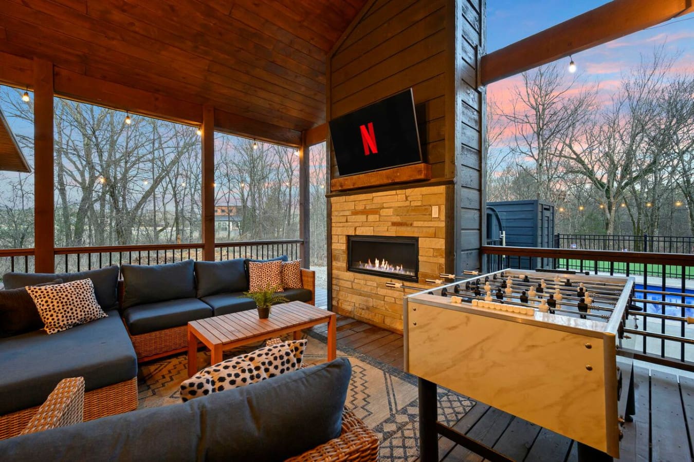 This covered patio is basically an outdoor living room with a fireplace, TV, foosball, and views for days.