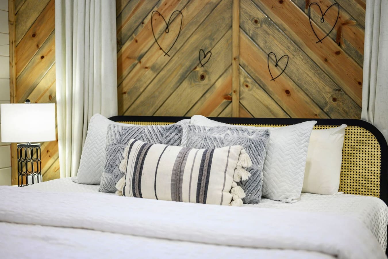 Cozy bed with crisp linens and a charming wooden accent wall perfect for a restful getaway.