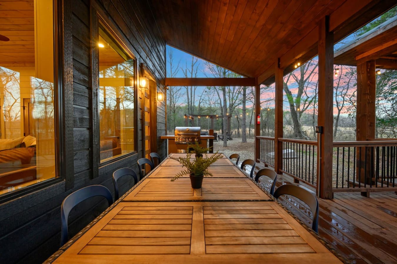 Covered deck with views of the woods and a built-in grill for entertaining.