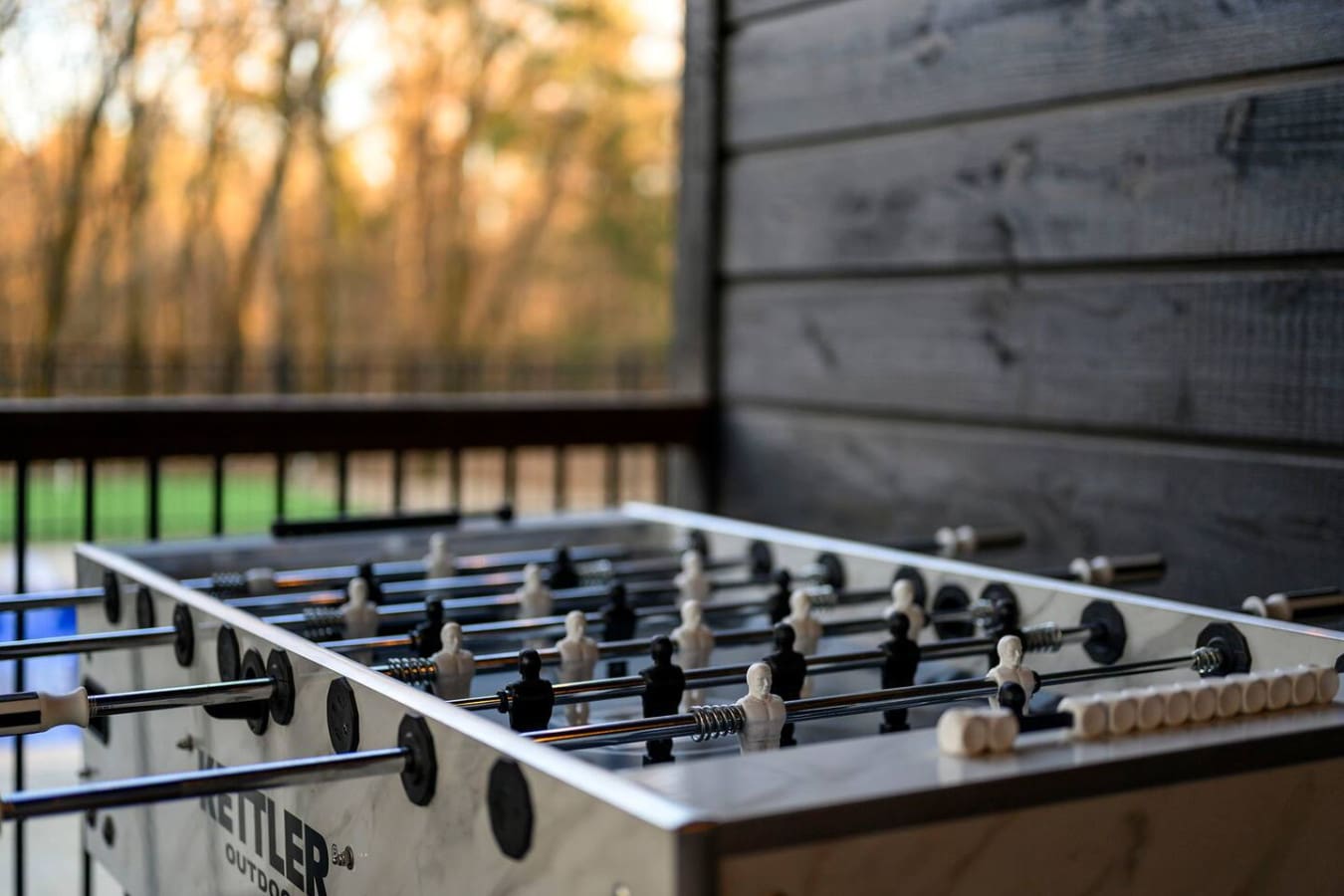 Game room with a view—foosball table overlooking the autumn trees and modern architecture.