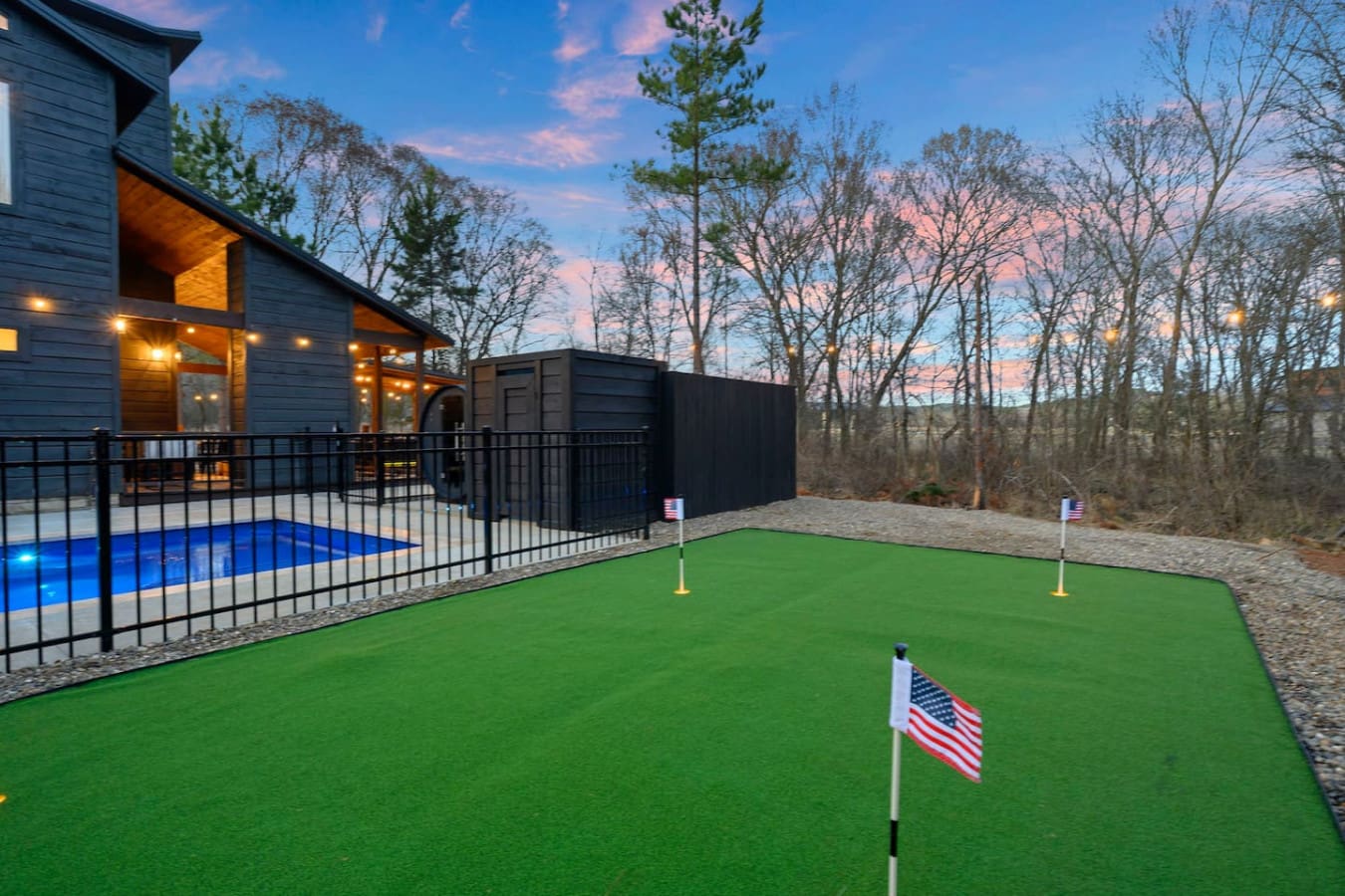 Check out this epic backyard setup with a putting green, heated pool, and those gorgeous wooded views at sunset.