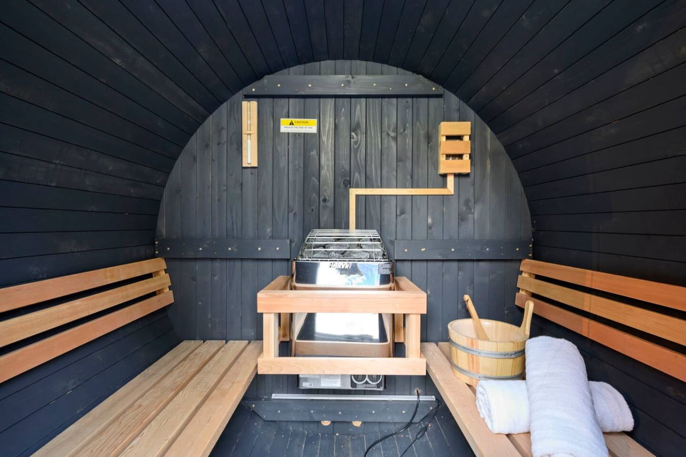 This barrel sauna features everything you need for a perfect steam session—benches, heater, and all the cozy towels.