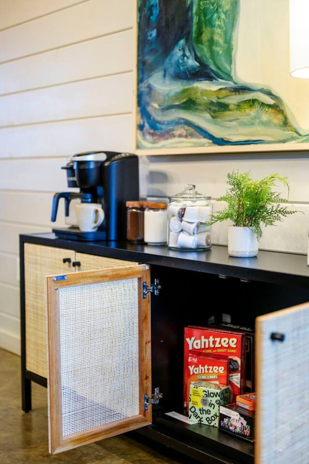 This stylish sideboard with shiplap walls and modern art makes the perfect spot to settle in and relax.