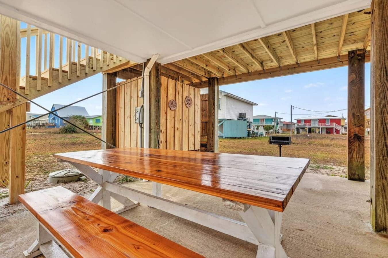 Covered picnic area with wooden tables and views of the colorful neighborhood homes.