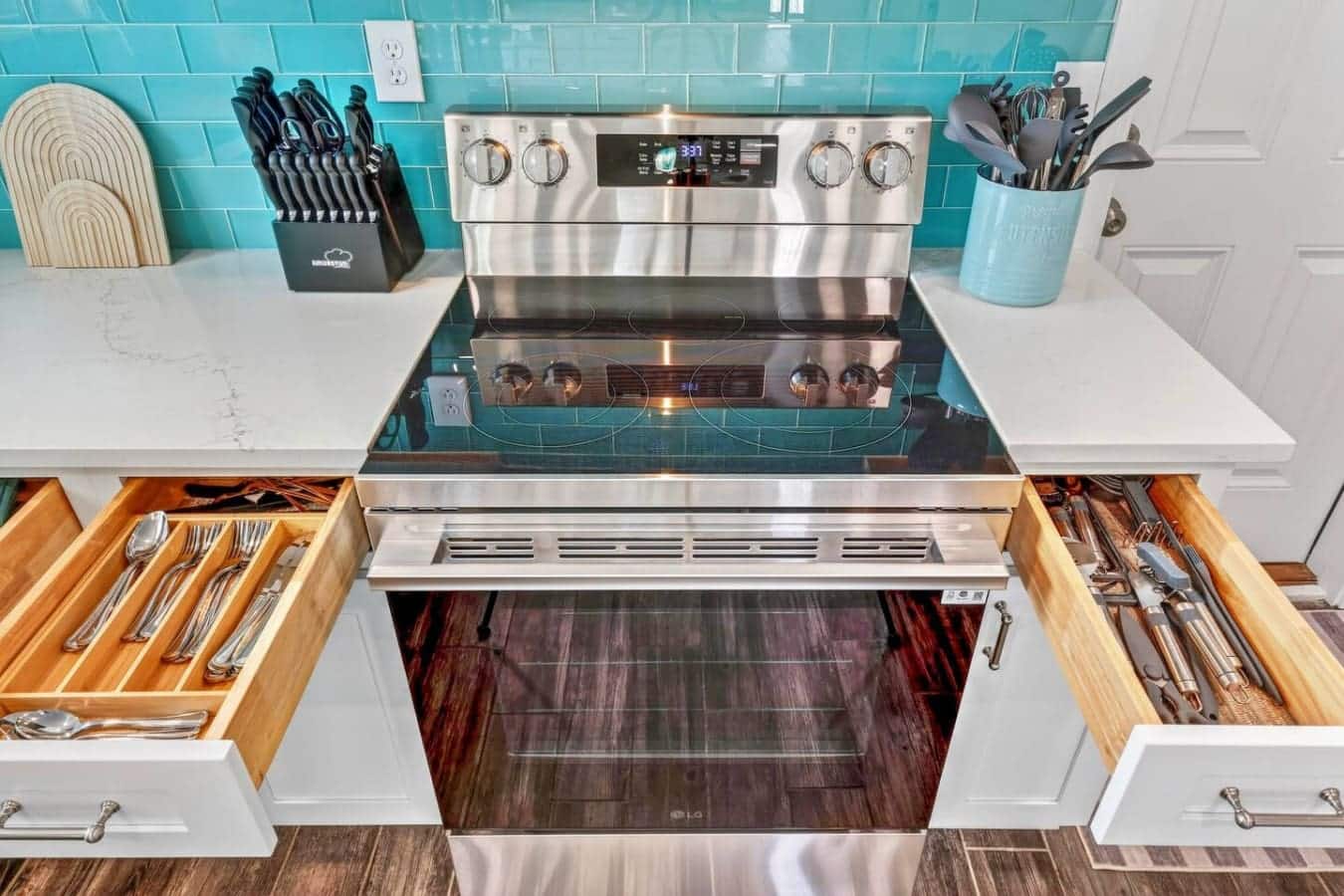 This gorgeous kitchen features stainless steel appliances, turquoise tile backsplash, and organized drawers for everything you need.