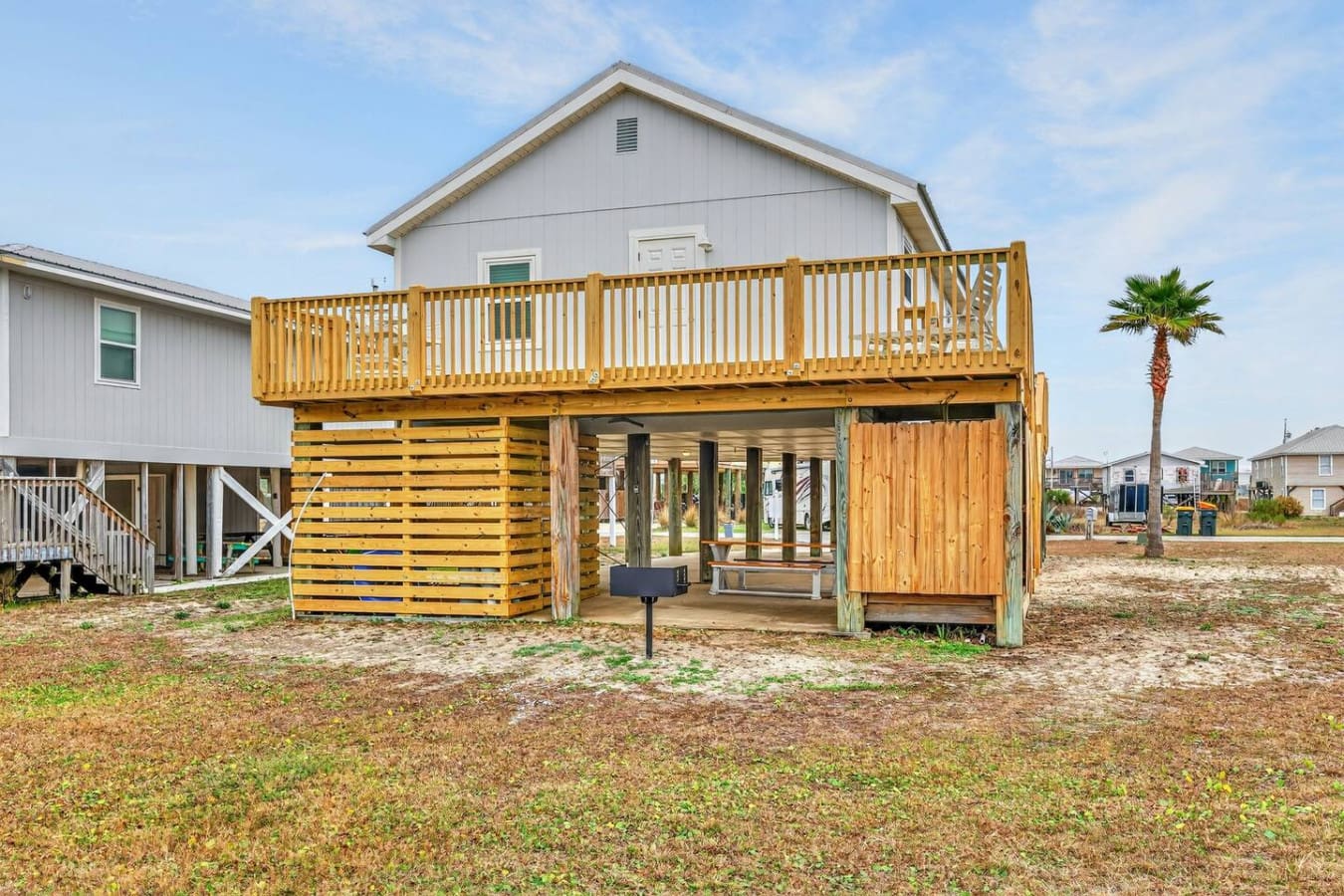 Check out this elevated beach house with a spacious wooden deck and covered outdoor living area perfect for the whole crew.