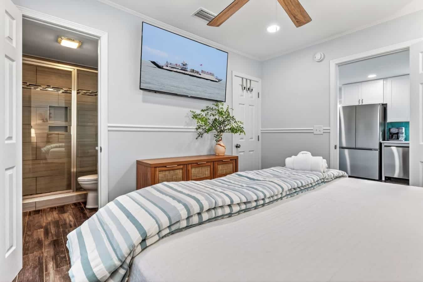 This master suite has everything—an ensuite bathroom, kitchenette, and a TV with water views to wake up to.