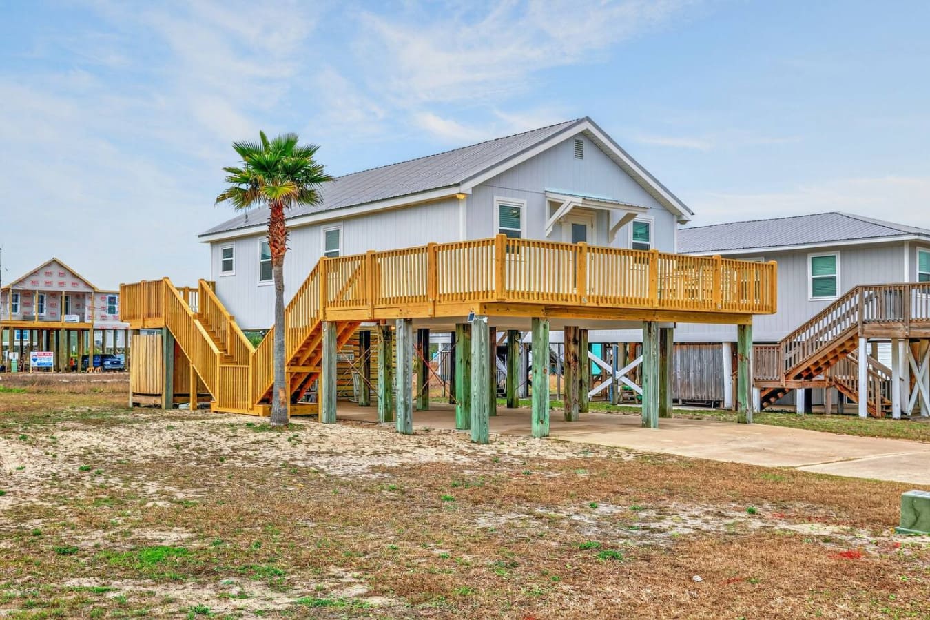 Beachfront beauty with a sprawling wooden deck and elevated stilts, perfect for catching ocean breezes and soaking up coastal vibes.