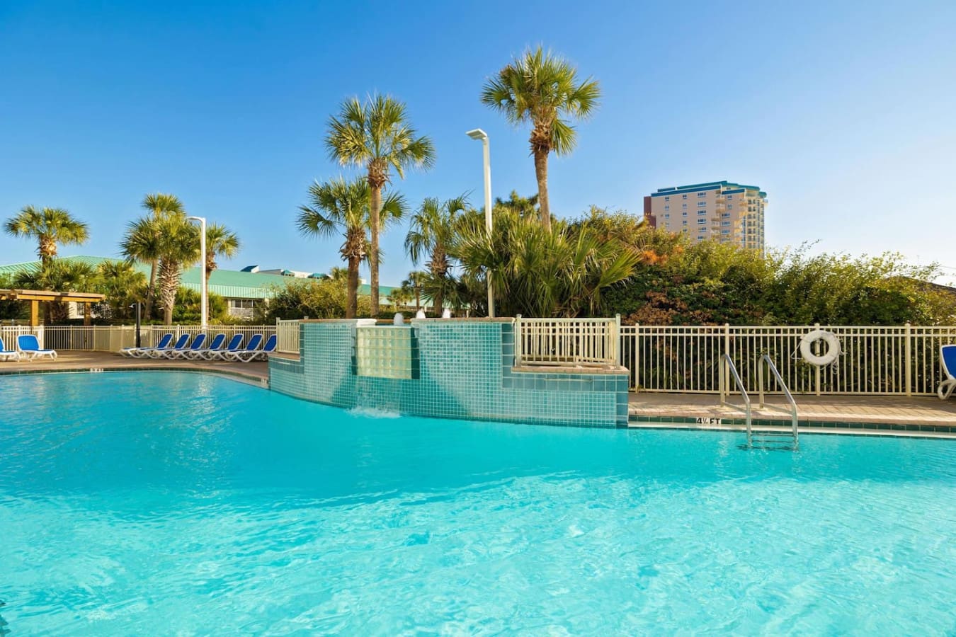 The main pool curves out in front of you like it was made for lazy afternoons—crystal-clear water, swaying palms framing the view, and that whole resort-to-ocean flow that makes it impossible to leave your lounger.