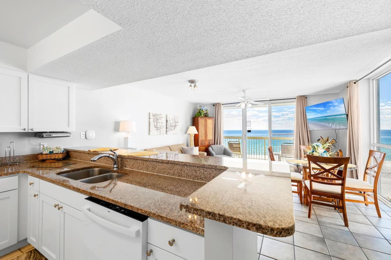 This kitchen-to-ocean view flow is basically the dream setup—whip up breakfast at the granite island, grab a seat at the dining table, and let those beachfront windows remind you that you're literally steps away from the sand and water.