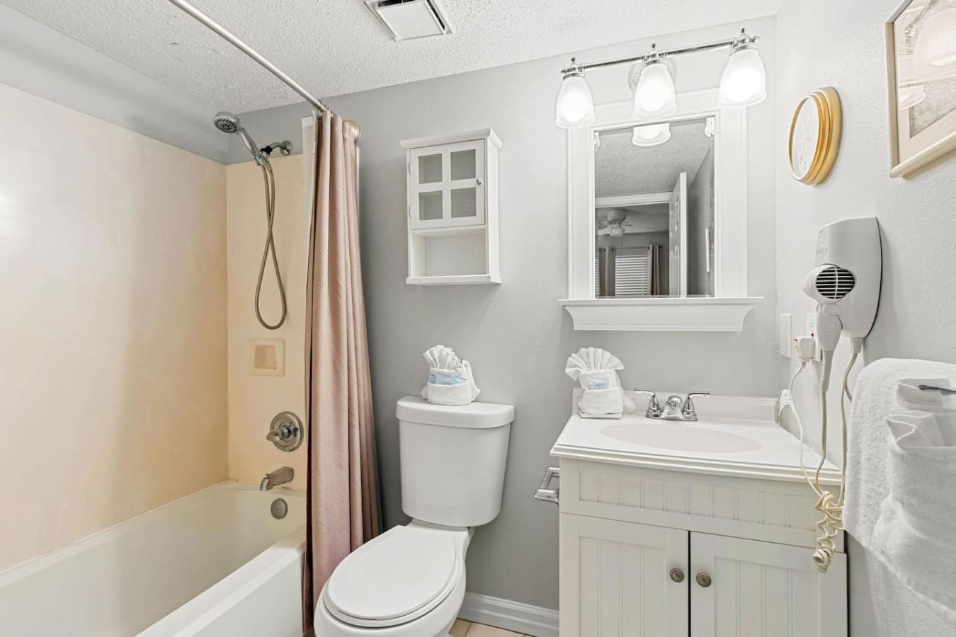 This spotless guest bathroom keeps things bright and functional with clean white fixtures and efficient storage—basically everything you need to freshen up between beach days without any fuss.