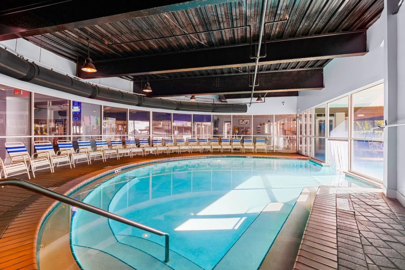 This indoor pool area gives you that best-of-both-worlds vibe—crystal-clear water, plenty of loungers, and those massive windows keeping the ocean in view while you float around in the heated comfort.