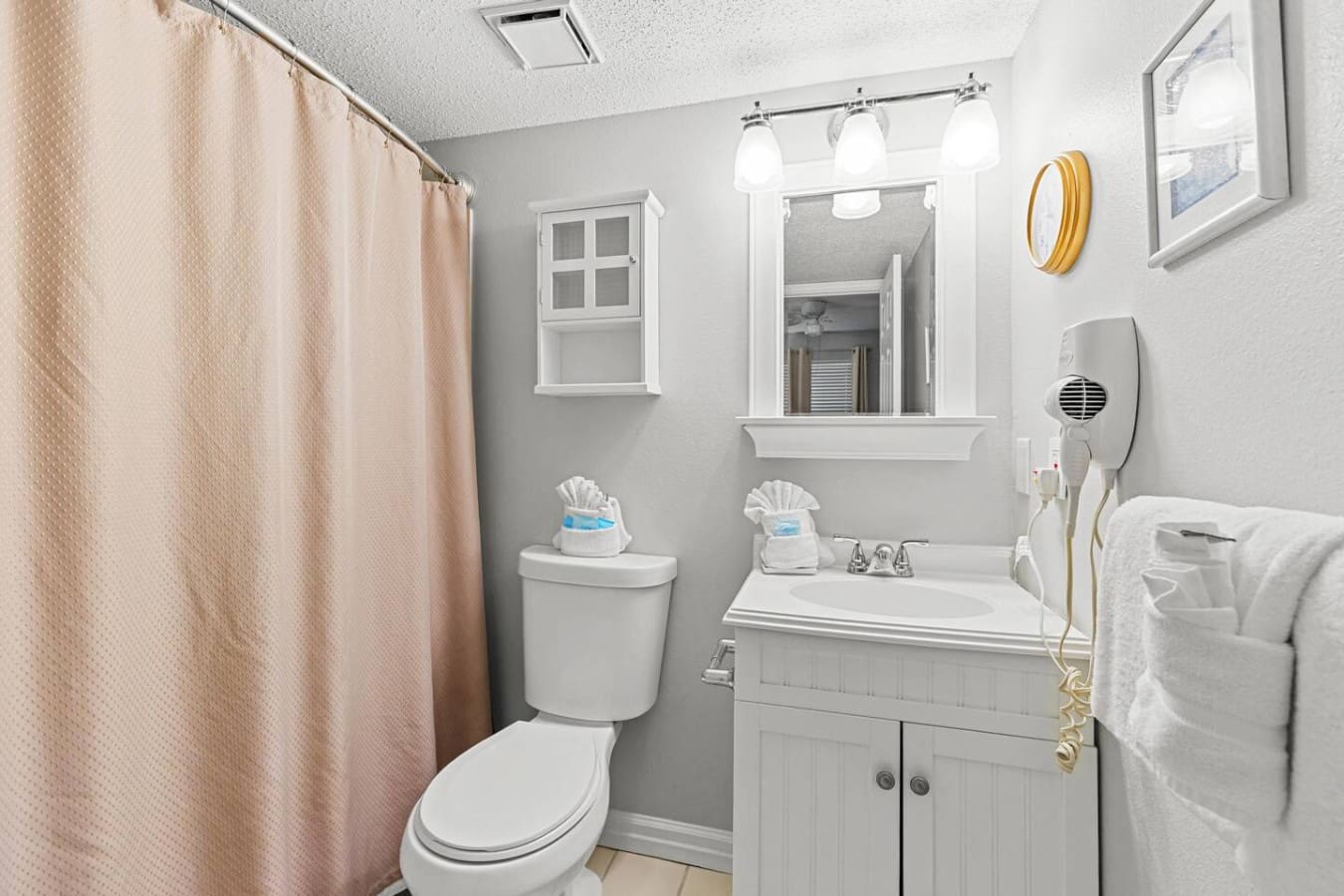 This neat-and-tidy bathroom has all the essentials to rinse off the salt and sand with ease, complete with bright vanity lighting and smart storage that keeps everything organized and accessible.