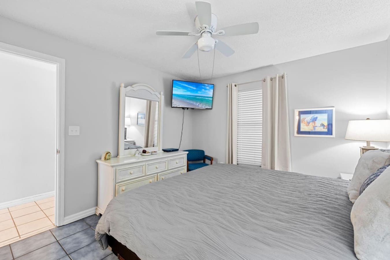 Wake up in this spacious master bedroom and you've got a flat-screen TV, a ceiling fan to keep things cool, and those ocean-view windows reminding you that the beach is basically your backyard.