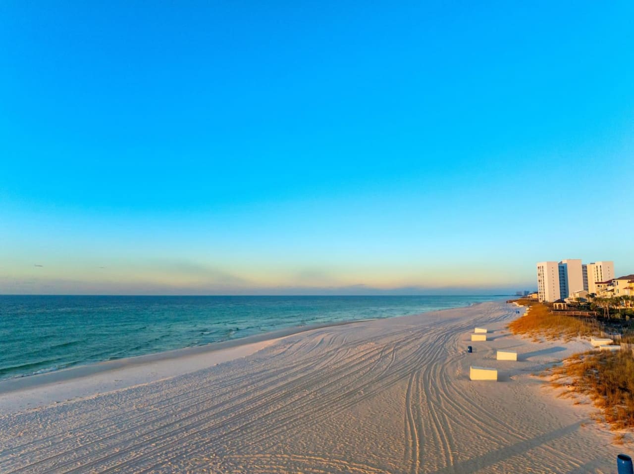 Golden hour hits different when you're standing on a stretch of pristine sand with those rippling patterns leading straight out to the turquoise water and nothing but horizon ahead.