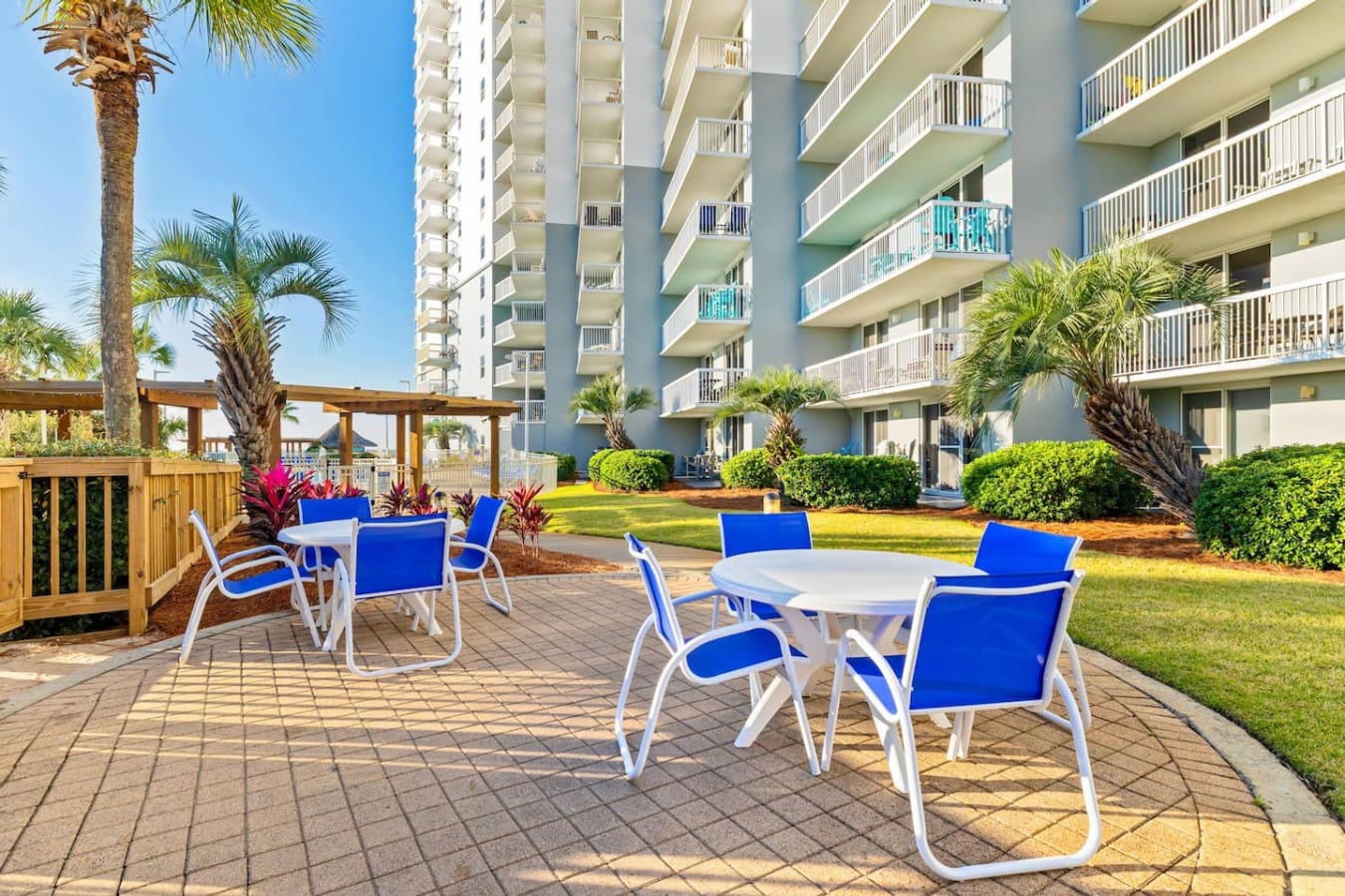 Grab a seat on the patio, settle into one of those blue loungers, and you've got the perfect setup to spend an afternoon watching the resort grounds, pool, and ocean all blend together without a care in the world.
