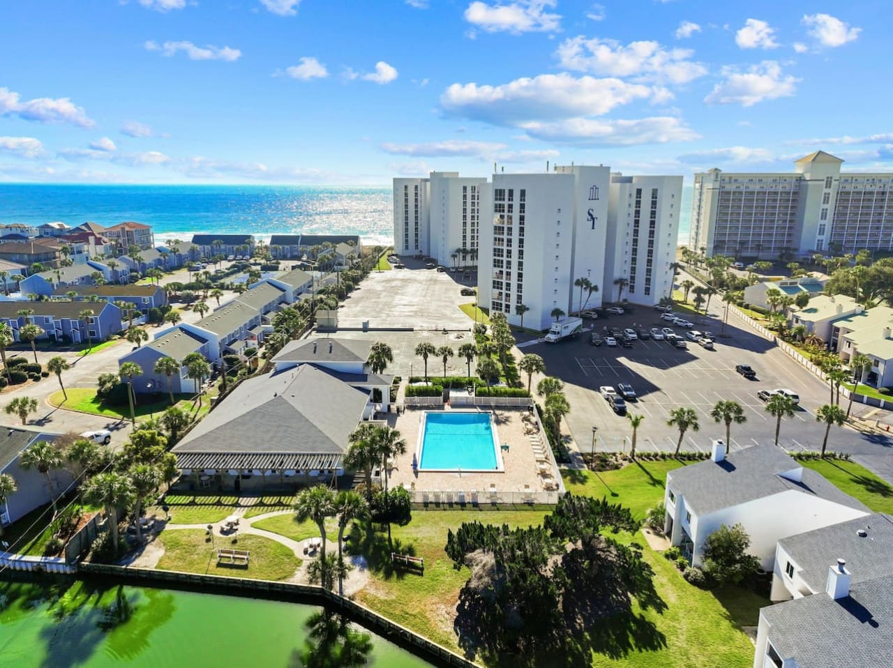 Sun-drenched aerial view of Shoreline Towers, showcasing the beautiful coastal surroundings, inviting outdoor spaces, and prime beachfront location.