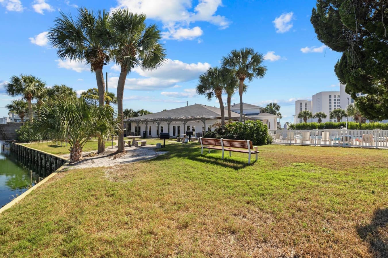 Lush green grass and swaying palm trees create a tropical, coastal ambiance around the property.