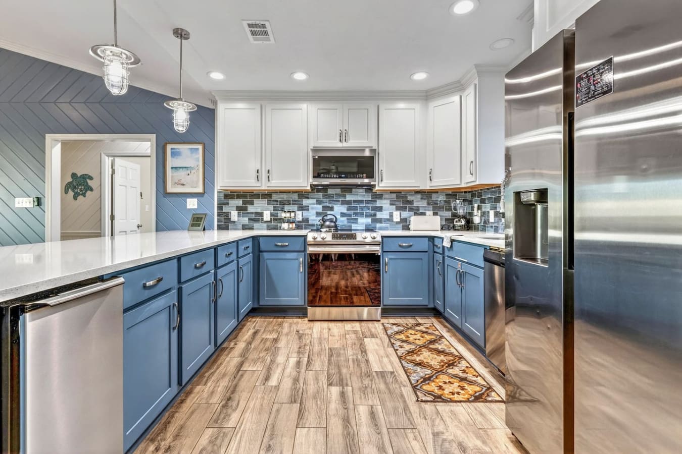 This chef's kitchen features stunning blue cabinetry, stainless steel appliances, and beautiful tile backsplash that'll make you never want to leave.