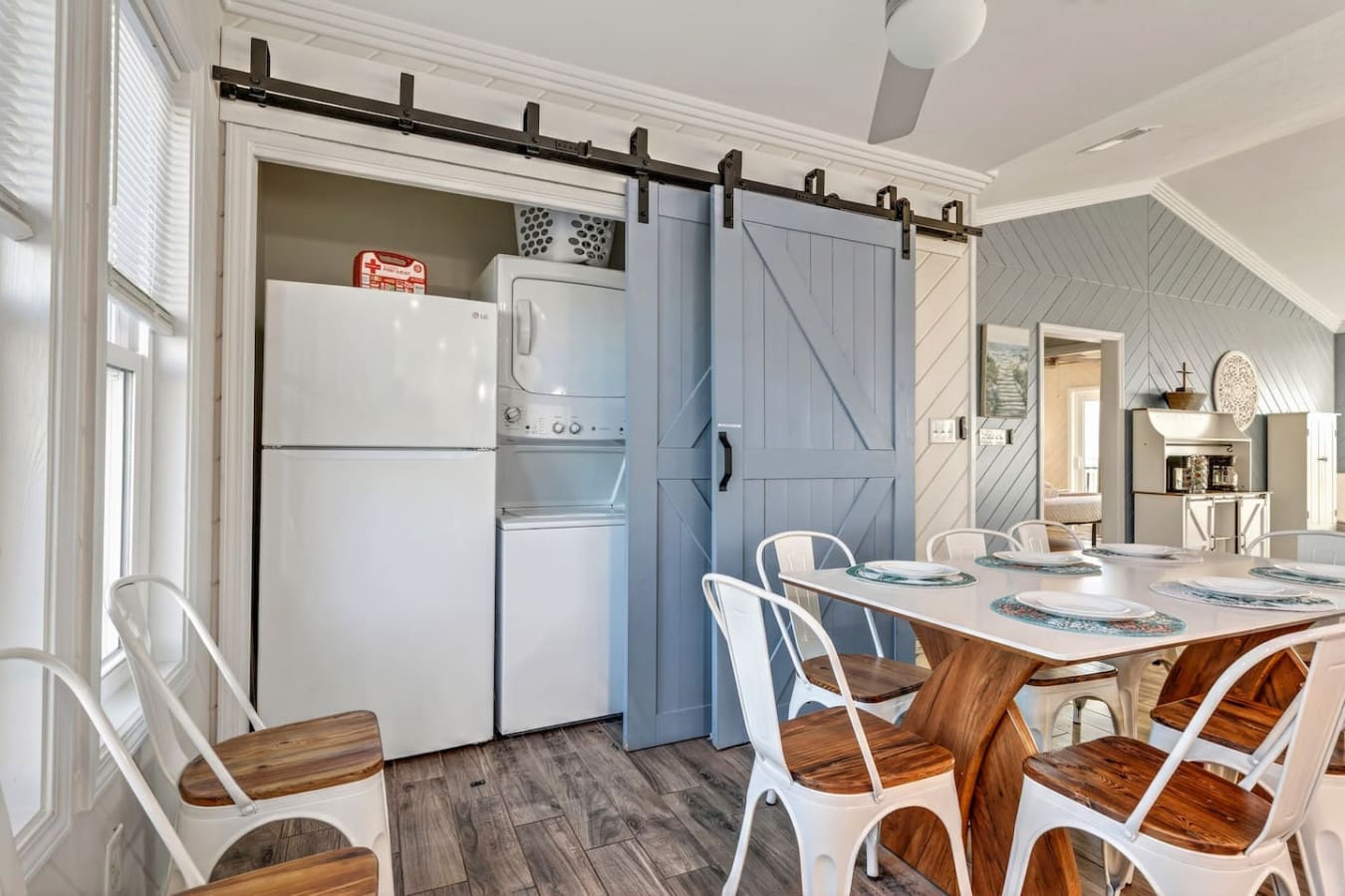 This bright, modern kitchen and dining area features sleek appliances, a sliding barn door, and plenty of space for the whole group.