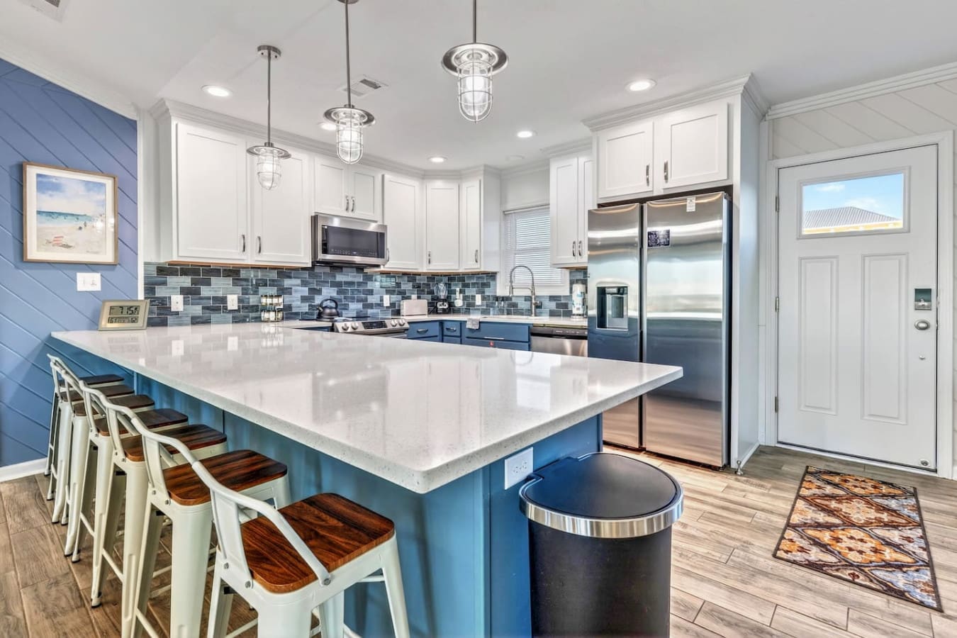This stunning coastal kitchen features a sprawling island, stainless steel appliances, and ocean views perfect for gathering.