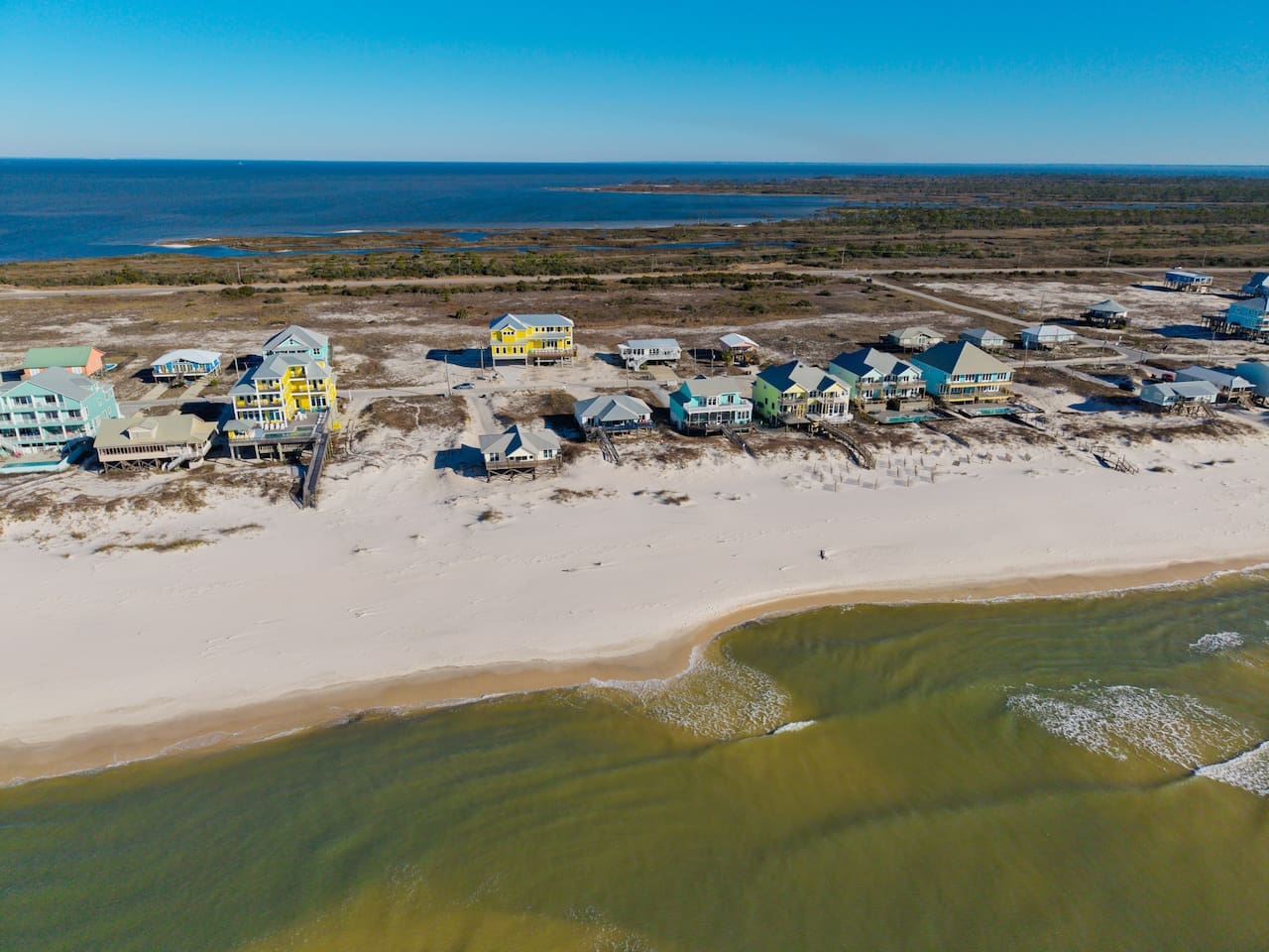 These colorful oceanfront homes line a pristine sandy beach with stunning views of the sound and barrier islands beyond.