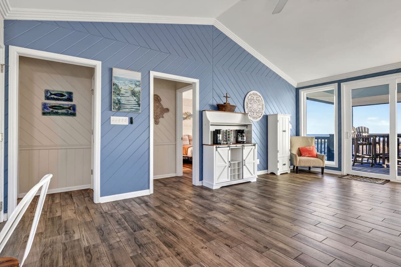 This airy loft space features stunning blue shiplap walls, beautiful hardwood floors, and direct access to an oceanview deck.