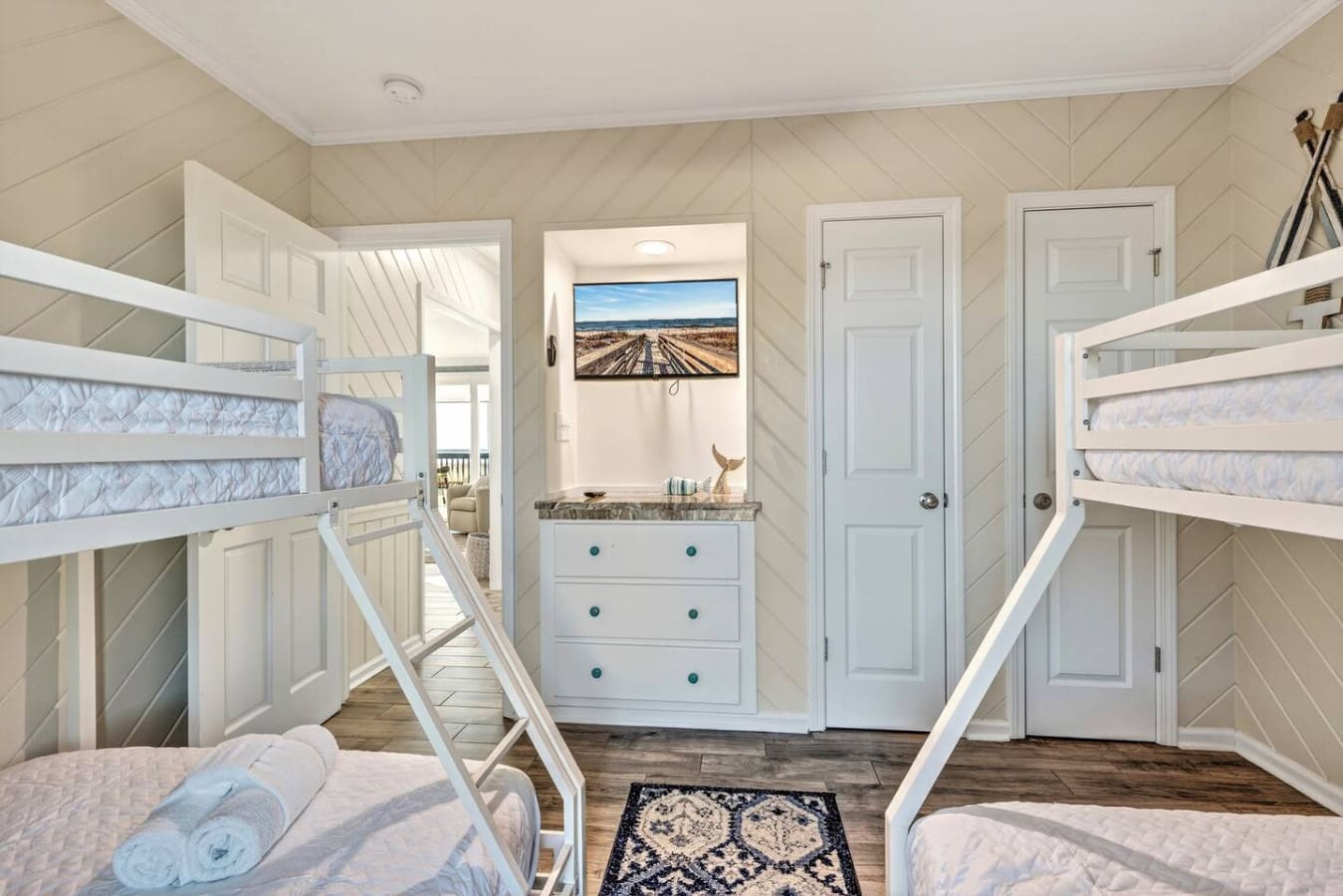 This bunk room is perfect for families or groups, with plenty of sleeping space and coastal charm throughout.