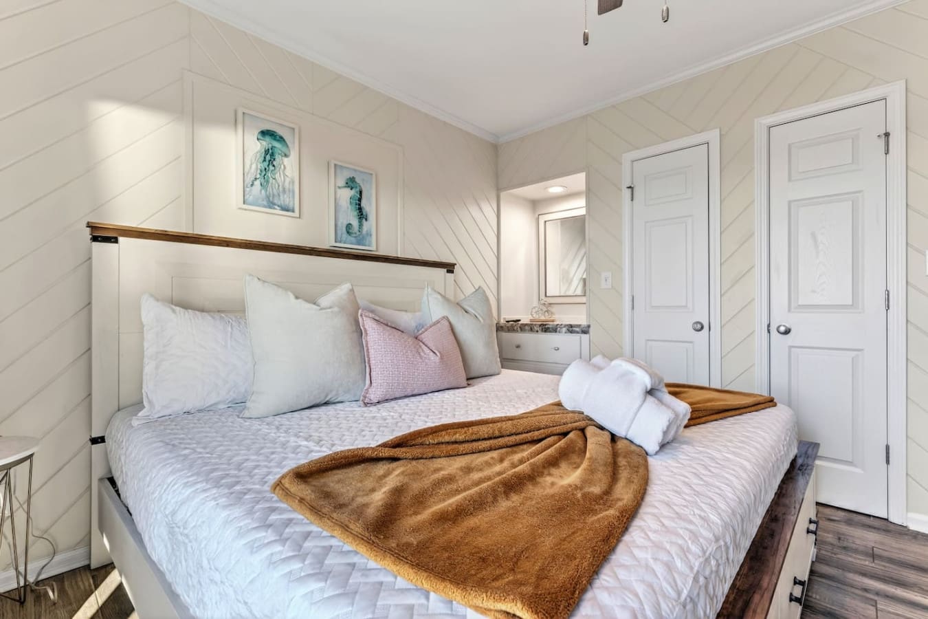 Bright, airy bedroom with shiplap walls, an ensuite bath, and those perfect coastal vibes you're looking for.