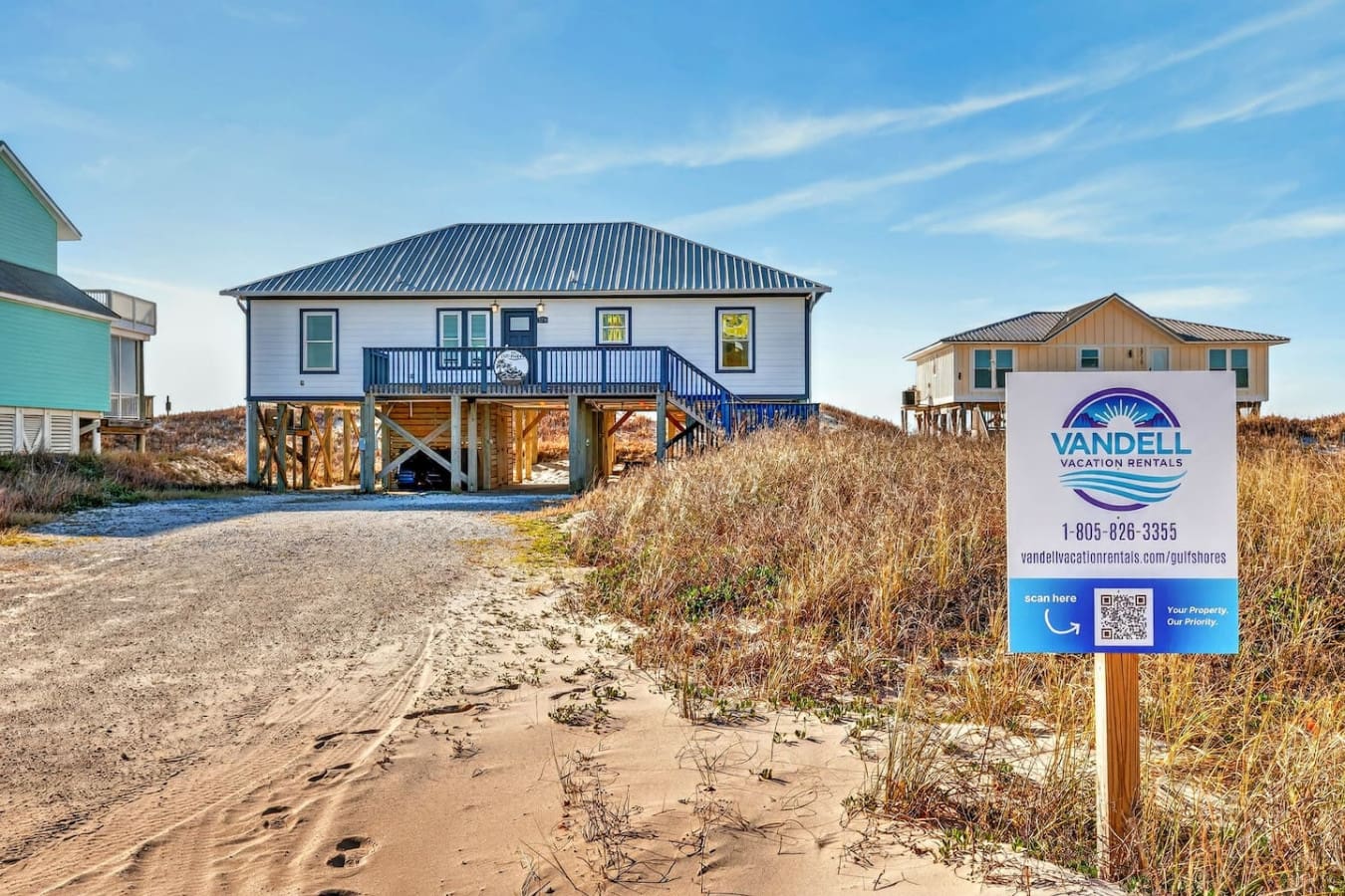 Modern beach house with wraparound deck, elevated on stilts, perfectly positioned right on the sandy dunes.