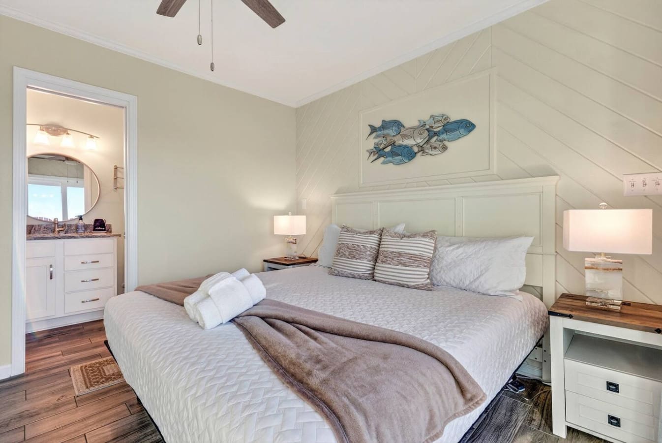 This bright coastal bedroom features a comfy king bed, an ensuite bathroom, and those vaulted ceilings that just feel amazing.