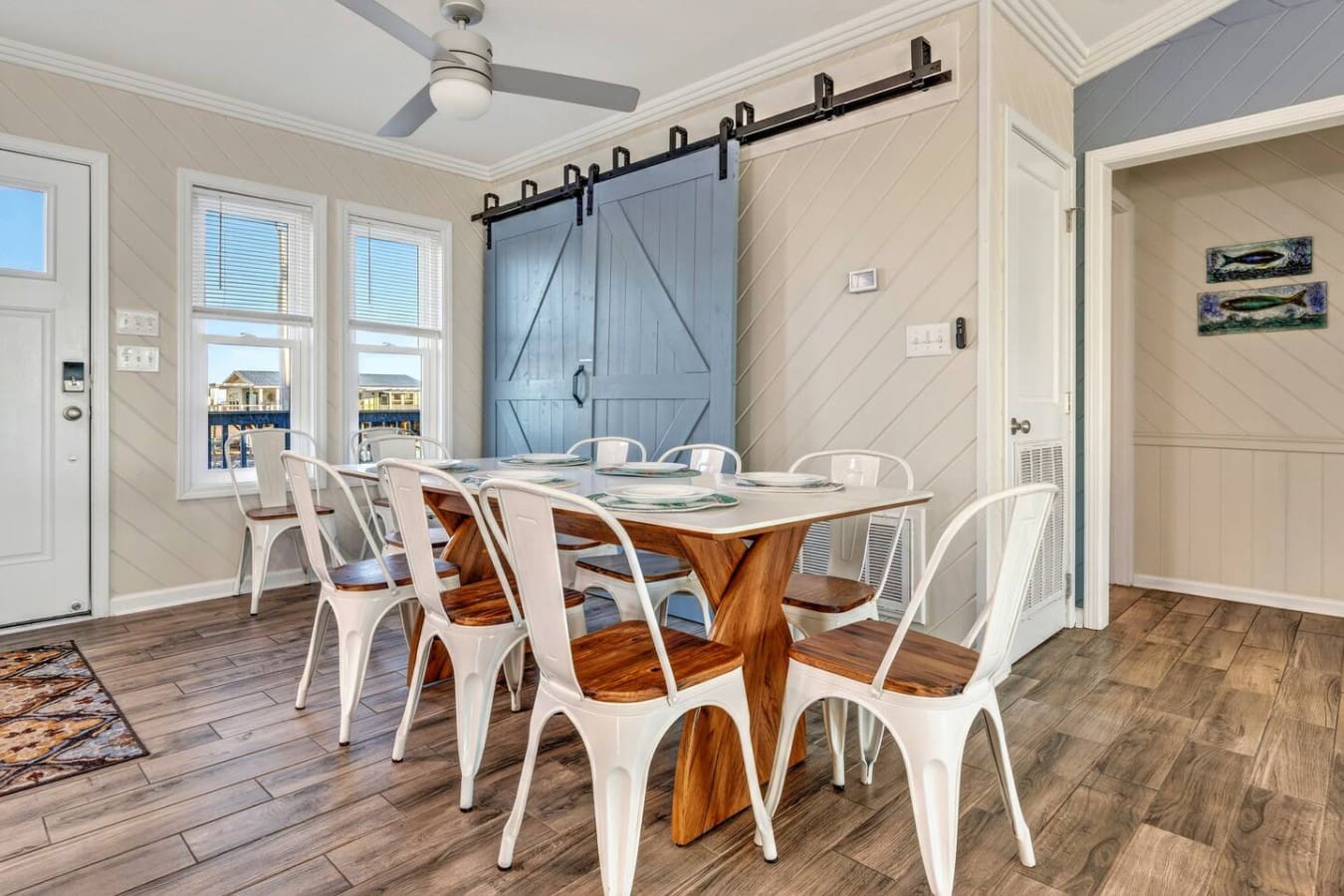 This light-filled dining area features stunning water views and a charming blue barn door that makes a serious design statement.
