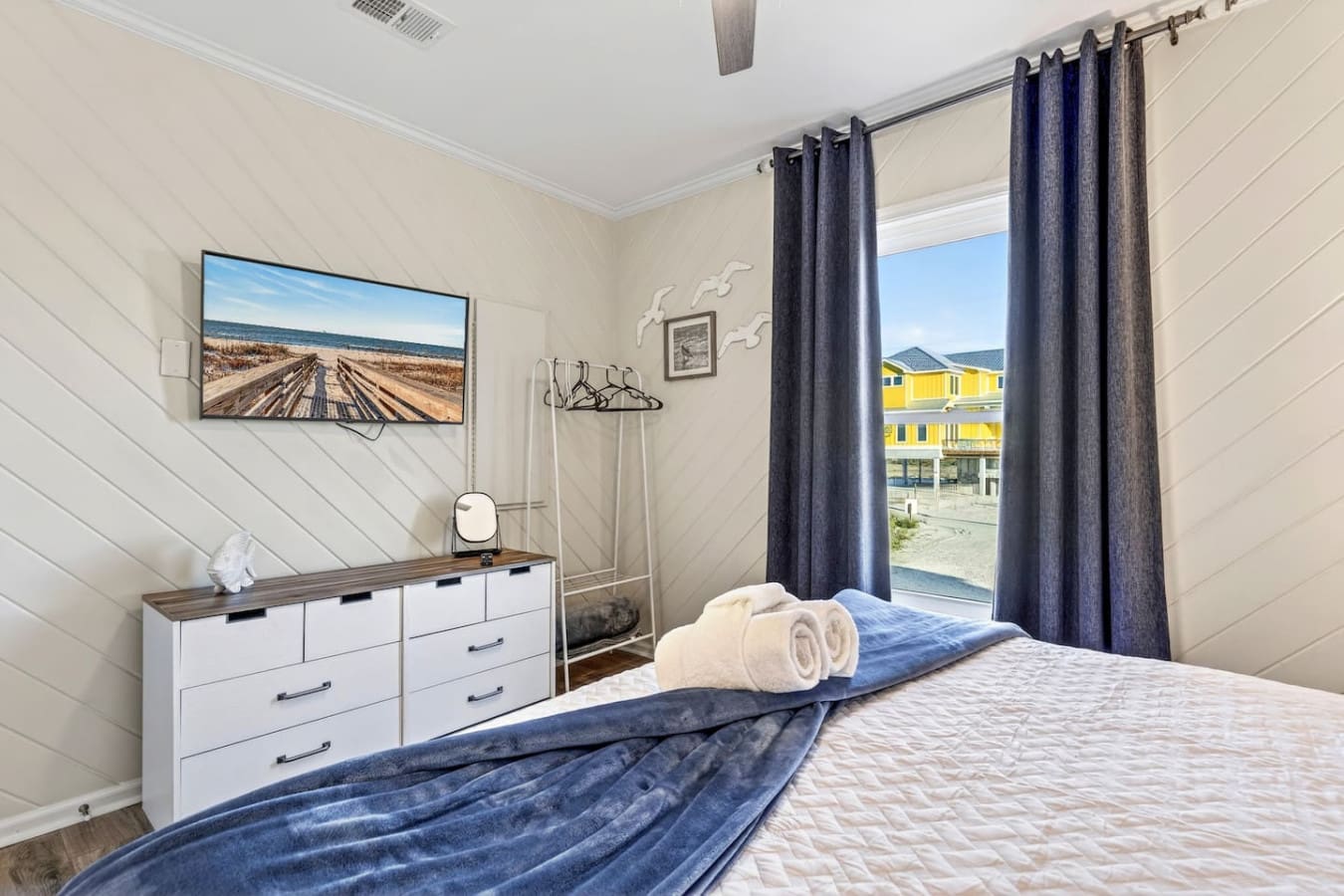 Cozy bedroom with shiplap walls, ocean views, and that perfect beachy vibe to unwind after a day out.