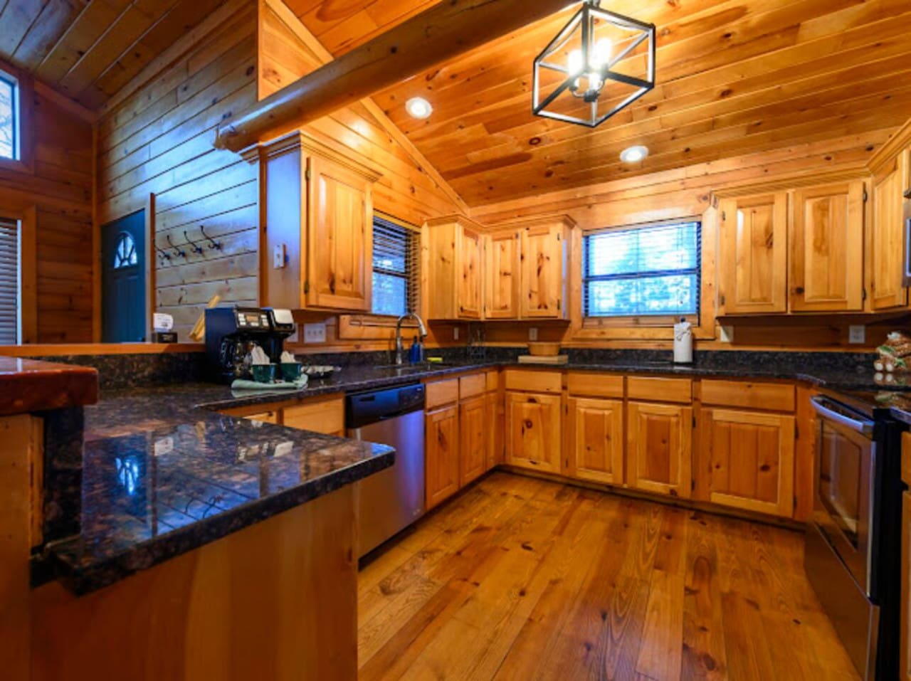 This gorgeous log cabin kitchen features custom wood cabinetry, granite countertops, and tons of natural light.