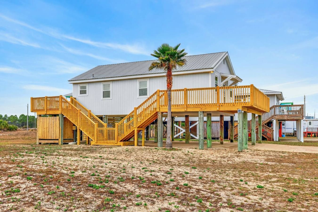 This elevated beach house sits right on the sand with a huge golden deck perfect for soaking up those coastal views.
