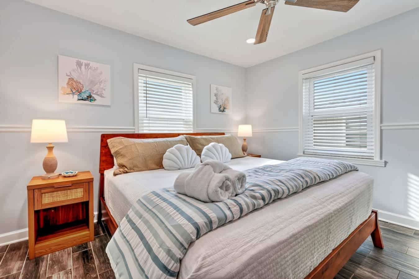 Wake up to ocean views and natural light in this serene bedroom with wood-beamed ceilings and plantation shutters.